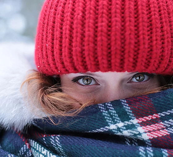 Vrouw gekleed in warm kleding om verkoudheid te voorkomen.  Helpt warme kleding tegen een verkoudheid?